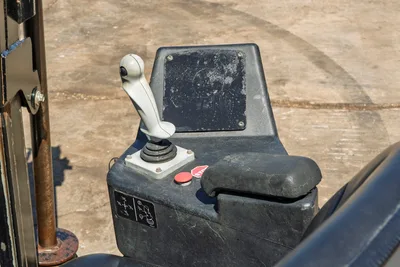 Close-up of Ditch Witch JT20 operator console, featuring drill control joystick, emergency stop, and armrest.