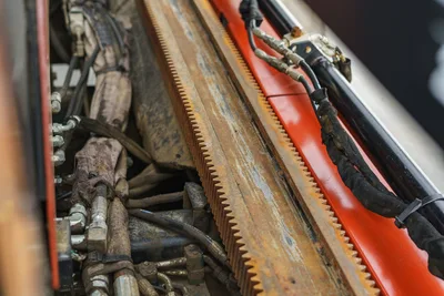 2015 Ditch Witch JT20 thrust rack gear teeth, hydraulic hoses, and bundled cables shown in close-up detail