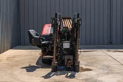 2022 Ditch Witch JT20 HDD drill, rear view showing loaded drill pipe rack, anchor posts, operator seat, and red engine hood