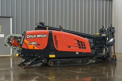 2015 Ditch Witch JT20 HDD drill, 3/4 side view, orange hood, pipe rack, carriage, tracks, drill pipe carousel, operator seat visible