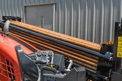 2023 Ditch Witch JT20 operator console with gauges, joystick controls, and loaded drill pipe rack viewed from elevated angle
