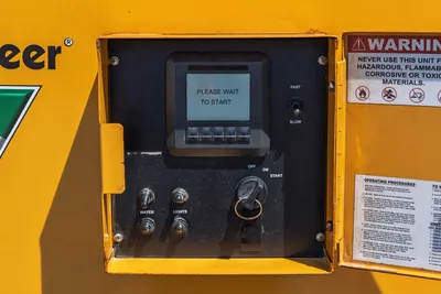 Vermeer LP873SDT vacuum excavator control panel showing LCD display, ignition switch, water/lights toggles, fast/slow switch, and warning decals.