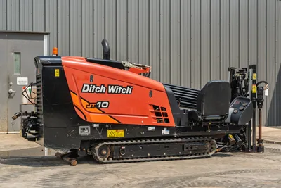 2018 Ditch Witch JT10 HDD drill, side profile, tracked undercarriage, operator seat, drill pipe rack, good condition.