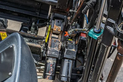 2018 Ditch Witch JT10 carriage and vise assembly overhead view showing hydraulic cylinders, rack drive, wear marks, and fluid lines