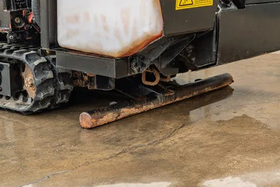 2016 Ditch Witch JT9 lower frame, rubber track, fluid tank, and worn anchor stake with surface rust visible