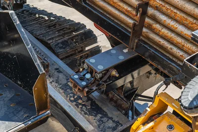 2020 Vermeer D24x40 S3 hydraulic manifold block and drill frame closeup, rubber tracks and used drill pipe visible