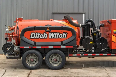 2023 Ditch Witch HX50 vacuum excavator, side view, orange tank with branding, blower, hose reel, tandem axle trailer