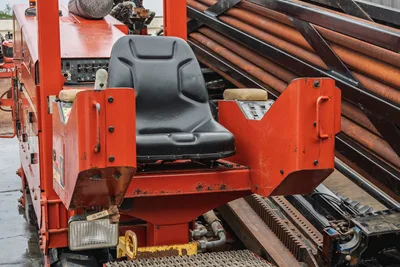 Operator station of Ditch Witch JT4020 MACH 1 HDD rig showing controls, seat, and drill pipe rack.