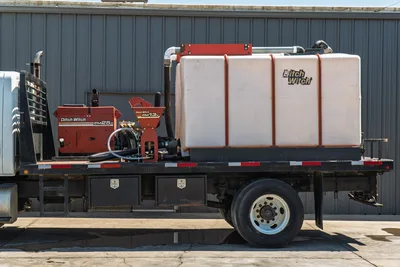 2015 International 7400 flatbed mud truck, Ditch Witch FM25 mixer, FM13v hopper, large white poly tank, toolboxes, side view