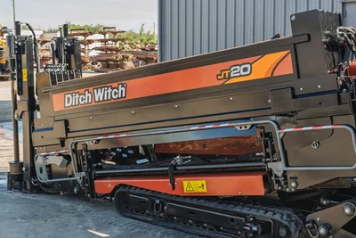 2023 Ditch Witch JT20 drill frame, side view with clean panels, tracks, drill pipe support structure, and safety decals.