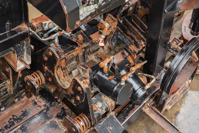 Ditch Witch JT4020 MACH 1 vise assembly, close-up high-angle view showing hydraulic cylinders, wear, and pipe clamps.