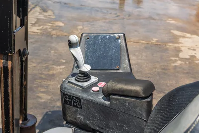 2023 Ditch Witch JT20 operator console closeup showing joystick control, stop button, armrest, and worn control panel