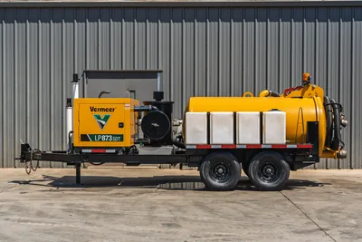 Vermeer LP873SDT trailer-mounted vacuum excavator, full driver-side profile view, yellow debris tank, white water tanks, dual-axle trailer