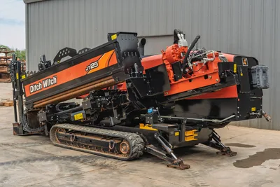 2021 Ditch Witch JT25 horizontal directional drill, side view showing tracks, pipe rack with drill pipe, and hydraulic head.