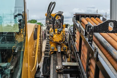 2017 Vermeer 40x55 S3 drill rig showing rack, drive head, hydraulic hoses, and stored drill pipe rack assembly.