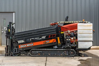 2018 Ditch Witch JT10 HDD drill, full side profile, loaded drill pipe rack, rubber tracks, fluid tank, hydraulic components visible