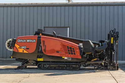 2023 Ditch Witch JT20 HDD drill rig, side view showing engine compartment, operator station, tracks, and drill pipe rack.