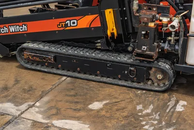 2018 Ditch Witch JT10 side profile, showing rubber tracks, Vise assembly, drill pipe rack, and hydraulic fittings.