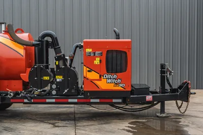 2019 Ditch Witch HX30 mud vacuum, profile view of orange engine compartment, suction hose, and trailer tongue components.