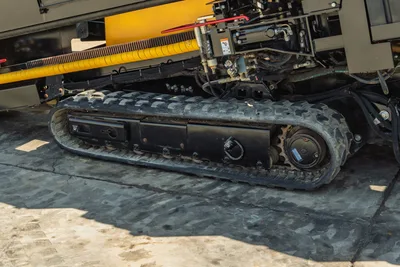 2022 Vermeer D23x30 S3 rubber track close-up showing tread, drive sprocket, hydraulic lines, and yellow drill carriage above