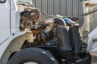 Side view of 2000 Freightliner FL80 mud truck engine bay showing open hood, Donaldson air intake, and turbo components.