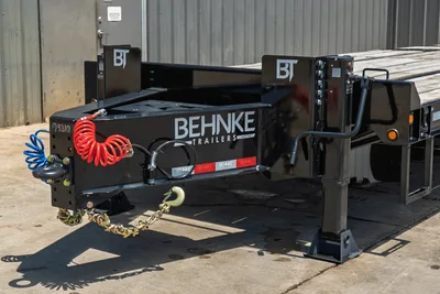 Behnke FB8X30SDPT-40L trailer hitch end showing pintle hitch, safety chains, coiled air lines, drop-leg jack, and BT uprights