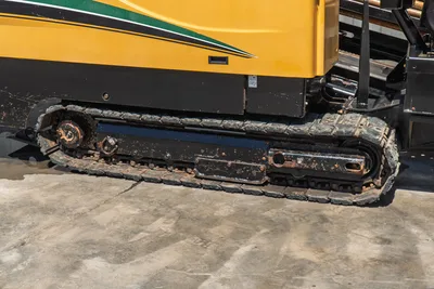2020 Vermeer D24x40 S3 rubber track undercarriage, close-up side view showing wear-worn track pads and drive sprocket