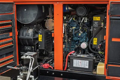 2021 Ditch Witch HX50 open engine compartment showing diesel engine, pump motor, battery, hoses, and caution labels