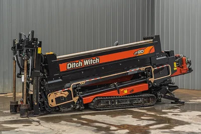 2018 Ditch Witch JT20 horizontal directional drill, side view, showing tracks, drill rod carriage, and mud pump assembly.