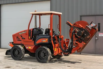 2017 Ditch Witch RT80 tractor in side profile with rear-mounted trencher attachment, open canopy, and heavy-duty tires.