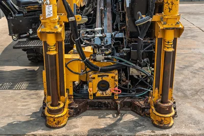 Rear view of 2014 Vermeer 24x40 Series II HDD drill showing hydraulic stabilizers, central vise assembly, and hydraulic hoses.