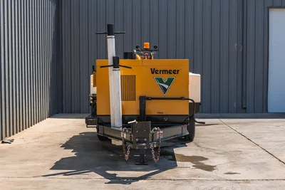 2025 Vermeer LP873SDT vacuum excavator rear view, trailer hitch with safety chains, yellow enclosure, amber beacon, exhaust stack