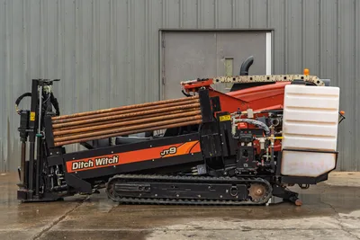 2016 Ditch Witch JT9 HDD drill, side profile, rubber tracks, loaded drill pipe rack, fluid tank, hydraulic system visible