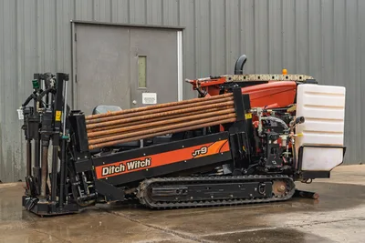 2016 Ditch Witch JT9 HDD drill, side view, rubber tracks, loaded drill pipe rack, hydraulic carriage, fluid tank visible