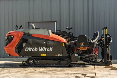 2020 Ditch Witch JT24 directional drill, side view showing engine housing, operator station, tracks, and drill pipe rack.