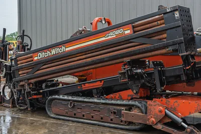 2008 Ditch Witch JT4020 MACH 1 side profile, tilted drill rack with pipe, rubber tracks, and orange chassis.