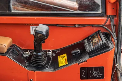 2016 Ditch Witch JT25 operator console close-up showing joystick control, display monitor, warning decals, and tan seat