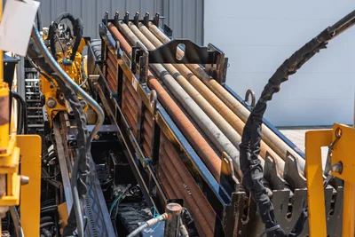 2020 Vermeer D24x40 S3 drill pipe rack loaded with used 2.375" HDD drill rods, yellow frame, hydraulic hoses visible
