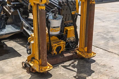 Vermeer D24x40 S3 drill frame close-up showing vise assembly, hydraulic components, anchor legs, and Vermeer Thread Pro bucket