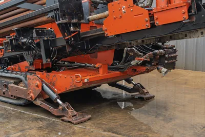 Ditch Witch JT4020 MACH 1 rear view showing orange steel frame, hydraulic stabilizer legs, drill pipe rack, and track system.
