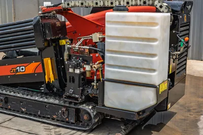 2018 Ditch Witch JT10 HDD drill, rear 3/4 view showing fluid tank, hydraulic components, drill pipe rack, and rubber tracks