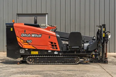 2018 Ditch Witch JT10 HDD drill, side profile, rubber tracks, operator seat, drill pipe rack, and engine compartment.