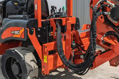 2017 Ditch Witch RT80 rear view showing hydraulic trenching attachment, heavy-duty hoses, control levers, and tires.