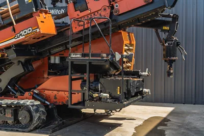 2014 Ditch Witch JT100 Mach 1 operator platform, carriage assembly, pipe loader arm, rubber tracks, side angle view showing wear