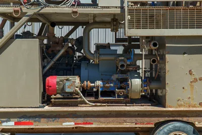 2018 Mud Technologies MCT-450 pump compartment showing electric motors, centrifugal pumps, piping, and trailer frame with surface wear