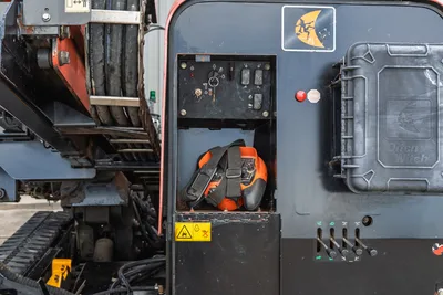 2021 Ditch Witch JT28 side control panel compartment with toggle switches, stored locator harness, and Ditch Witch branded access panel