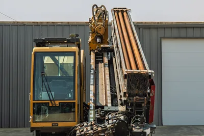 2017 Vermeer D100x140 S3 HDD drill, front view showing enclosed cab, elevated drill frame, spindle, and loaded pipe rack with 3.5" drill pipe