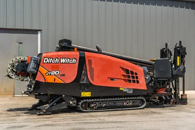 2021 Ditch Witch JT20 HDD drill, passenger-side view, orange hood, drill pipe loaded, pipe carousel, rubber tracks, operator console visible