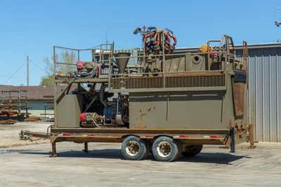 2018 Mud Technologies MCT-450 trailer-mounted mud recycler, side view, dual-axle, shaker deck, mixing hopper, pump assembly, red fittings visible