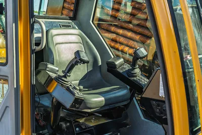 Vermeer 40x55DR S3 cab interior with dual joystick controls, operator seat, instrument panel, and 2.625" drill pipe storage visible through window